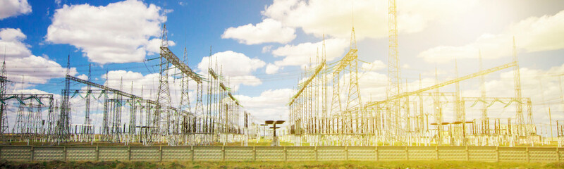 power plant and transformer towers close-up in the steppe, against the blue sky