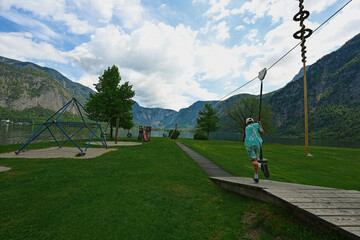 Boy swinging on rope at playground Hallstatt, Austria.