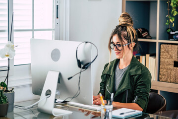 Young woman entrepreneur at work on computer in home office workplace. Modern female people with...
