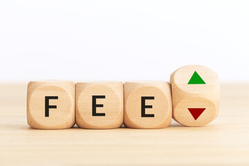 Fee going up or down concept: Wooden blocks with text and up and down arrows