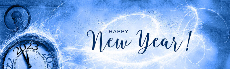 Happy New Year 2023 - Greeting card with English text, Silvester clock, fireworks and snow - Panorama, banner, header with copy space - Abstract background, New year´s eve 
