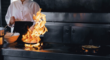 Process professional chef and fire. Woman cooking food vegetables open fire, photo slow motion freeze time