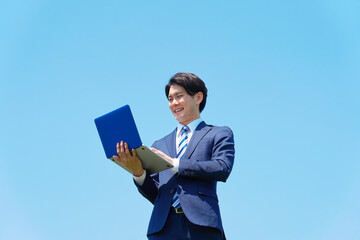 屋外でパソコンを使うビジネスマン