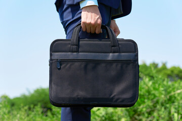 屋外でカバンを持つビジネスマンのクローズアップ
