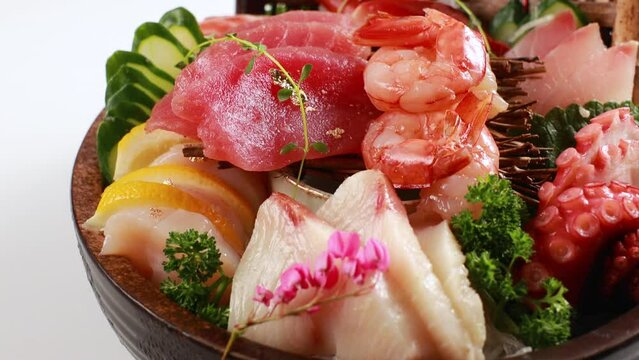 Mix fresh sashimi. Salmon fish shrimp tuna and squid on tub. Japanese food on restaurant table.