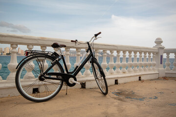 Bicicleta alquilada para pasear por las calles de la ciudad de Benidorm mientras los turistas están de vacaciones para poder hacer algo de ejercicio. - obrazy, fototapety, plakaty