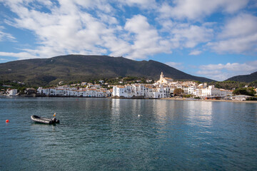 Lancha motora en medio del tranquilo mar azul del pequeño pueblo pesquero de Cadaqués con las verdes montañas de fondo.