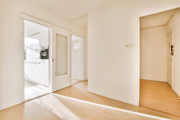 an empty room with white walls and wood flooring on either side of the room, there is a door...