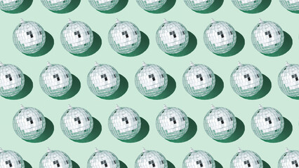 Shiny silver disco balls over green background. Creative Christmas pattern. 90s retro party time concept. Xmas holiday background. Top view. Flat lay.
