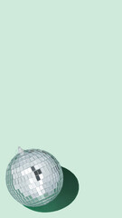 Shiny silver disco balls over green background. Creative Christmas pattern. 90s retro party time concept. Xmas holiday background. Top view. Flat lay. Copy space