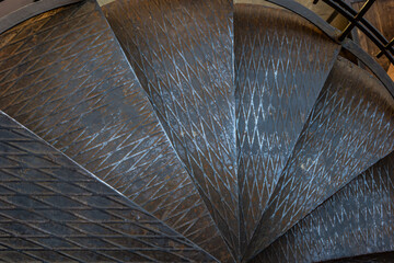 Pattern on metal black stair around the metal pole