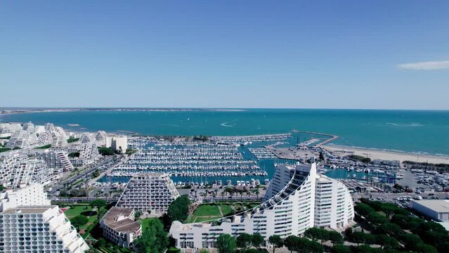 Aerial view of large marina of with pyramid buildings during sunny day with blue sky in La Grande Motte