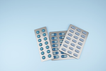 Blue pills, tablets and capsules in blister packaging on pink blue background. Illustration of the concept of men drugs