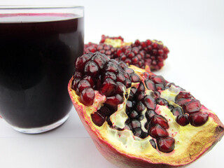    A glass of pomegranate juice and pomegranate fruit.        