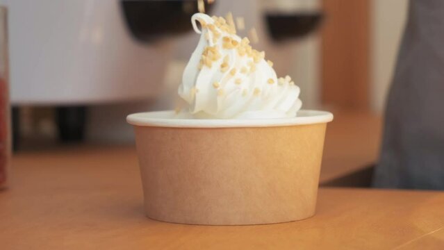 Closeup shot of chef hand decorating ice cream with cherry and peanuts. yogurt ice cream with cherries and peanuts