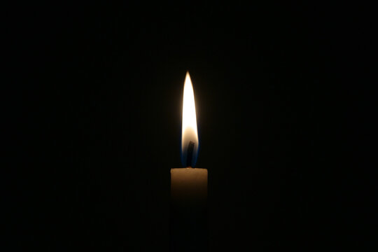 A lit candle against a black background