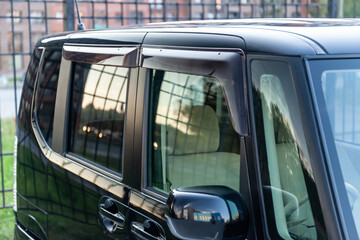 Close-up of the side windows of a car sedan with plastic darkened pads protecting against wind and...