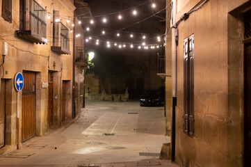 Walking at night on old medieval streets of Elciego village illuminated with Christmas lights, Rioja Alavesa, Spain