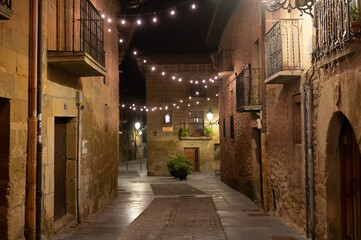 Walking at night on old medieval streets of Elciego village illuminated with Christmas lights, Rioja Alavesa, Spain