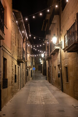 Fototapeta na wymiar Walking at night on old medieval streets of Elciego village illuminated with Christmas lights, Rioja Alavesa, Spain