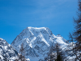 Arolla, Switzerland - April 10th 2022: View towards an high alpine peak with glaciers and rocks