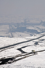 A huge excavator on a surface coal mine in winter conditions. Interesting appearance of surface mining under snow.