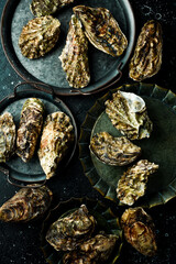 Set of fresh oysters. Traditional serving for food. On a black stone background. Top view.