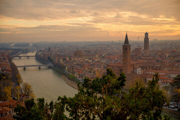 Fantastic picturesque view to Verona and river Adige in flame sundown haze from Castle San Pietro