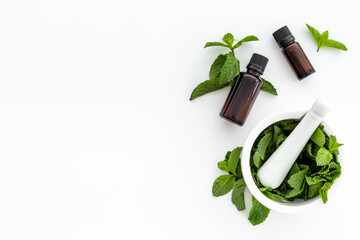 Peppermint essential oil - source of menthol. Mint leaves with bottle of oil