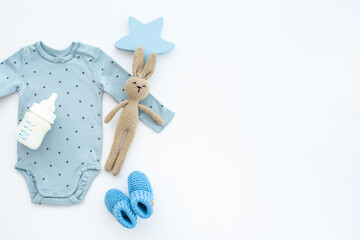 Newborn baby bodysuit with rabbit toy, flat lay, top view