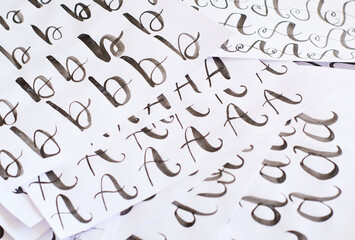 Several white sheets with calligraphic exercises. Calligraphy practice.
