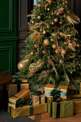 beautiful christmas tree with golden decorations and gifts in boxes underneath