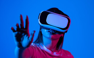 Brunette woman wearing VR virtual reality headset touching air during the VR on Metaverse experience. Technology, Video Game and Metaverse Concept.