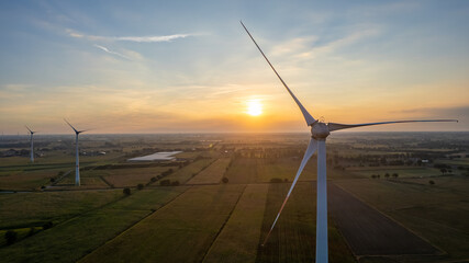 Wind farm with wind Turbine in a rural area against the sunset seen from an aerial view shot by a...