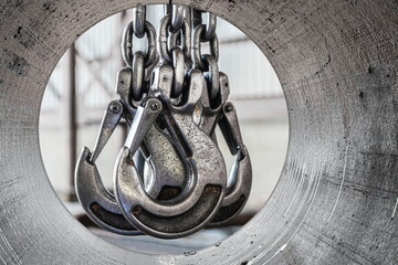 Lifting mechanism iron chain with a hook of an overhead crane on the background of an industrial...