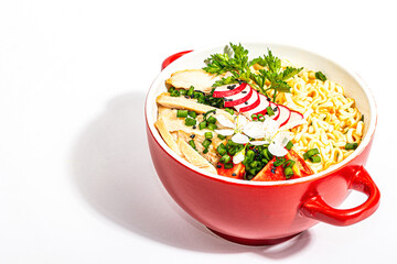 Asian noodles with chicken, vegetables, and herbs are isolated on a white background