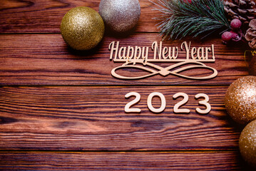 Happy new year 2023 on wooden brown background
