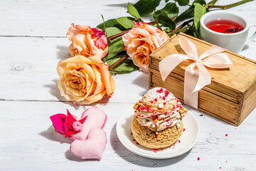 The concept of romantic gift. French Shu cake, hibiscus tea, bouquet of roses, festive decor