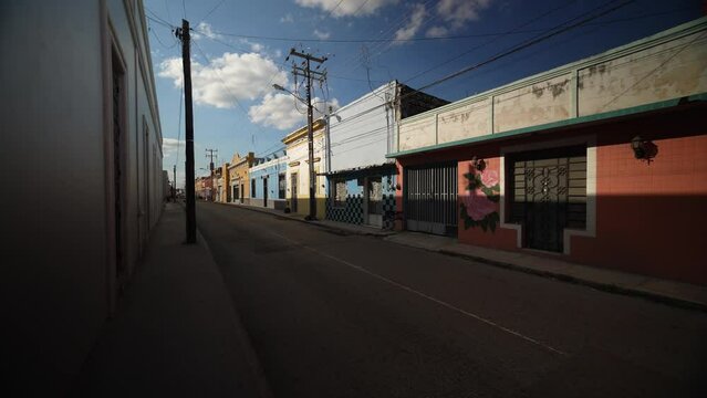 Slow motion push in down a deserted street showing colorful buildings in Mexico, Merida, Yucatan in early evening.