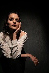 beautiful brunette woman in white shirt and black underwear in the dark