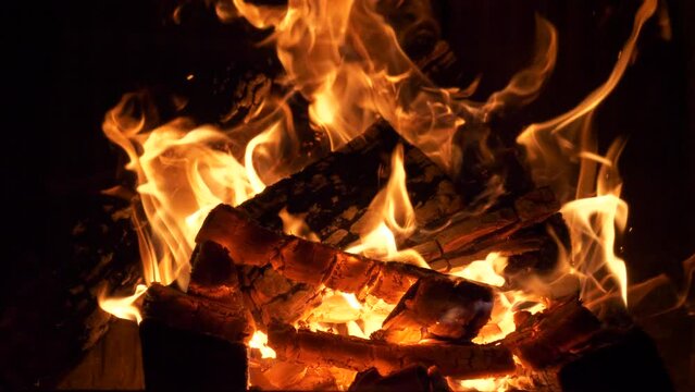 Beautiful shot of camp and fireplace fire burning in the dark at night.