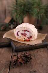 Meringue roll with strawberries on a wooden board
