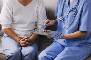 Homecare nursing service and elderly people cardiology healthcare. Close up of young hispanic female doctor nurse check mature caucasian man patient heartbeat using stethoscope during visit