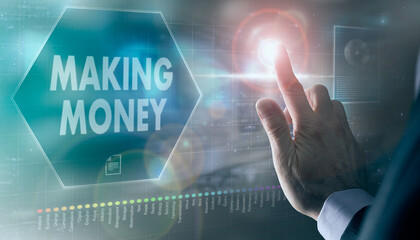 A businessman controlling a futuristic display with a Making Money business concept on it.