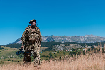 Army soldier holding a sniper rifle with scope and walking in the forest. war, army, technology and...