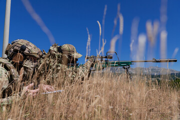 Sniper soldier assisted by an assistant to observe the area to be targeted with modern warfare...