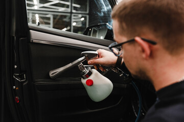 A man cleans a car and dries the interior with a dry cleaning gun. Manual car cleaning. Car...