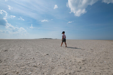  A boy walks on the beach of Ameland The Netherlands.