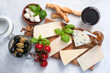 Käseplatte mit verschiedenen französischen Käsestücken, Oliven, Tomaten und Rotwein