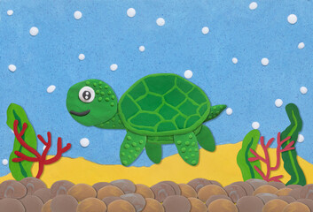 green turtle made from plasticine on under water background